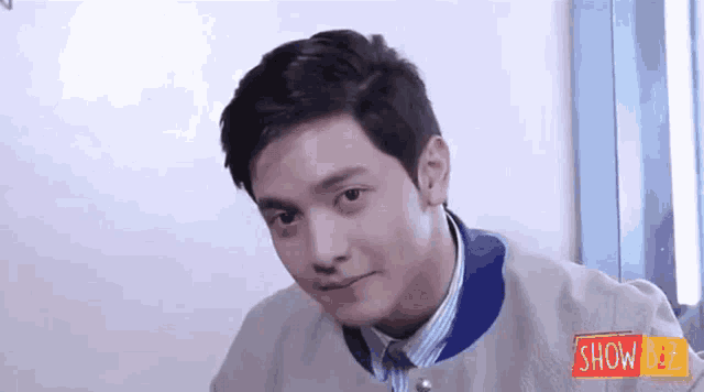 a young man is making a funny face while wearing a jacket and tie .