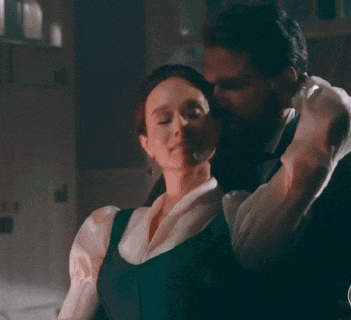 a man kissing a woman on the neck in a room