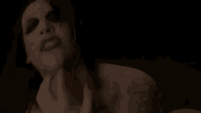 a woman is making a funny face with her mouth open in a black and white photo .