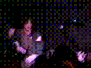 a blurry picture of a person playing drums in a crowd