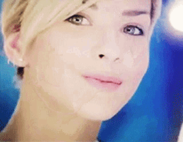 a close up of a woman 's face with blue eyes