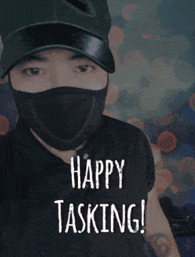 a man wearing a mask says happy tasking in front of a green background