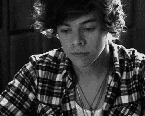 harry styles is wearing a plaid shirt and necklaces