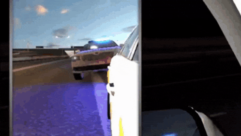 a phone screen shows a police car driving down a road