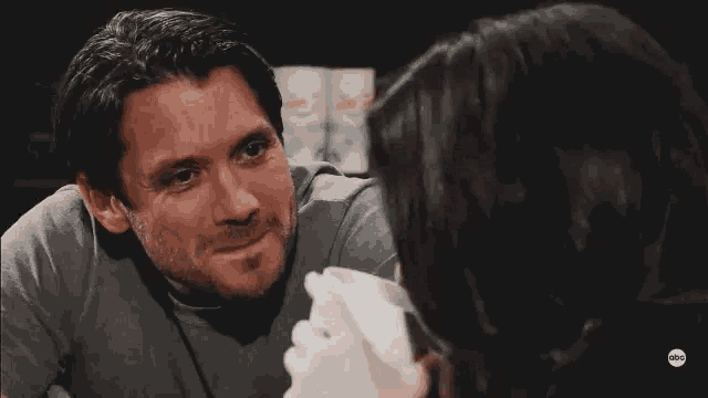 a man and a woman are looking at each other in a restaurant .