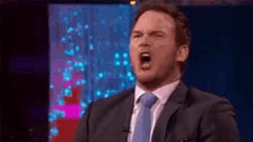 a man in a suit and tie is making a funny face .