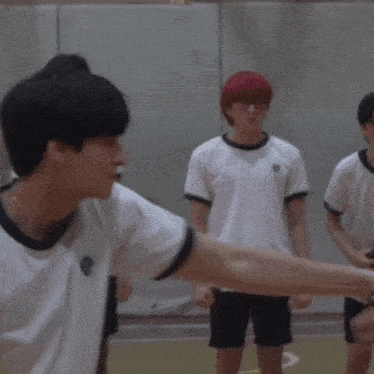 a group of young men are shaking hands on a court