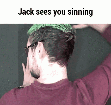 a man with green hair and glasses is wearing a red shirt and covering his face .