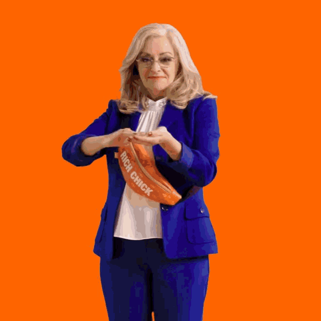 a woman in a blue suit has a fanny pack that says rich chick on it