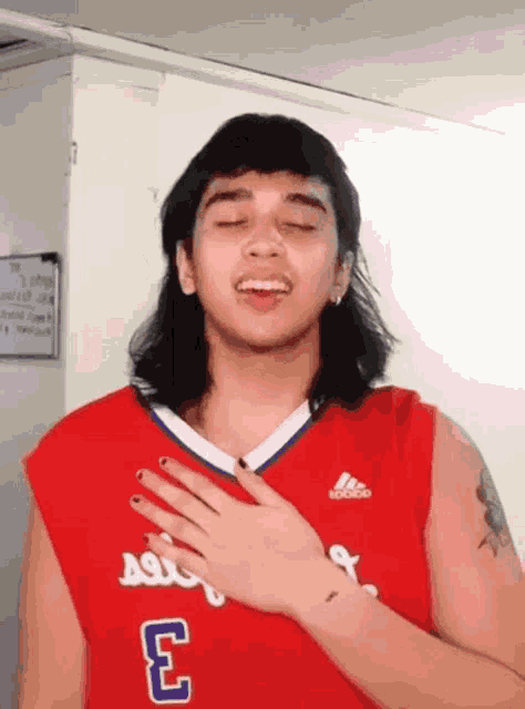 a young man wearing a red adidas jersey with the number 3 on it