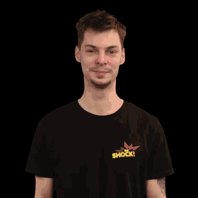 a man wearing a black shirt that says " the shock "