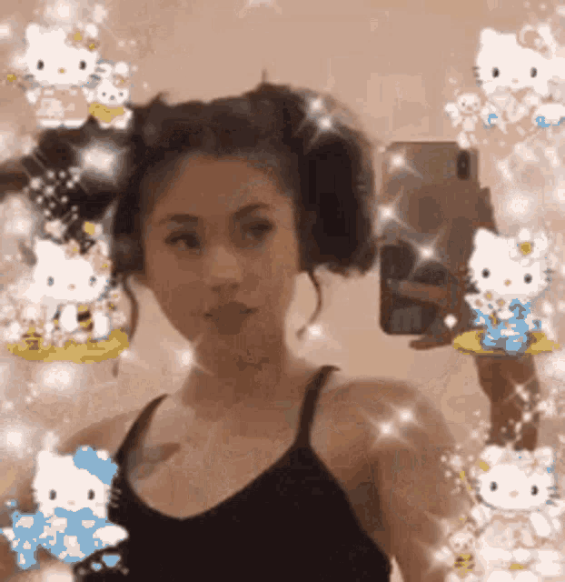 a woman is taking a selfie in front of a mirror surrounded by hello kitty stickers .