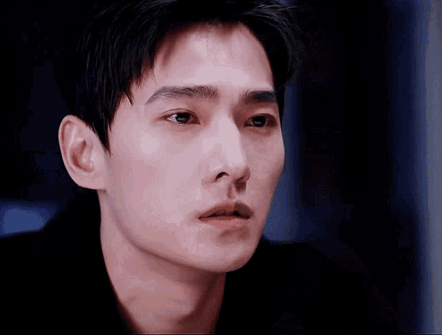 a close up of a young man 's face with his eyes closed and his mouth open .