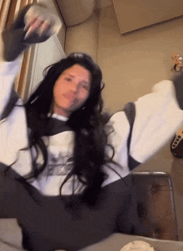 a woman wearing a white and black sweatshirt with a ny on it