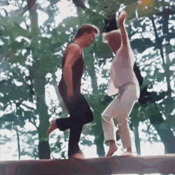 a couple of people are dancing in the woods
