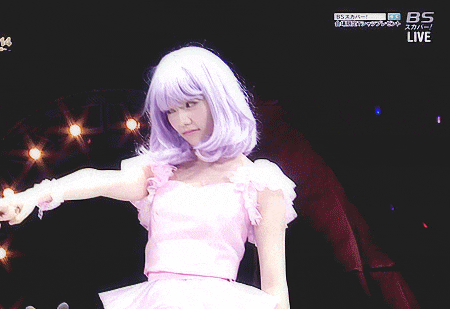 a woman wearing a purple wig and a white dress is on a bs live show