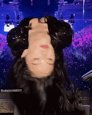 a woman is standing upside down on a stage .