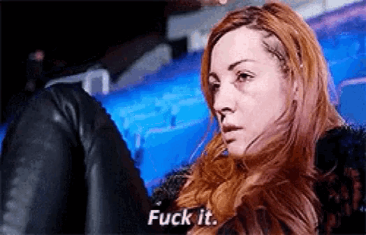a woman with red hair is sitting in a dark room and says `` fuck it '' .
