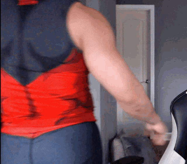a man in a red shirt and blue pants is standing in a room