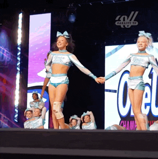 cheerleaders on a stage with a large screen behind them that says champs