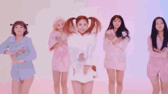 a group of young women are standing next to each other in a room .