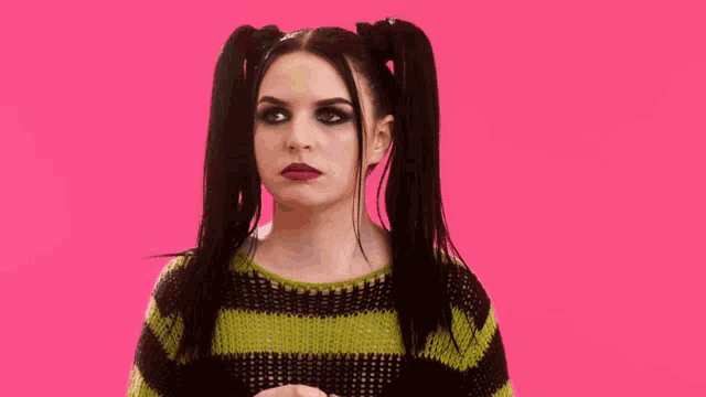 a woman with pigtails is wearing a green and black striped shirt