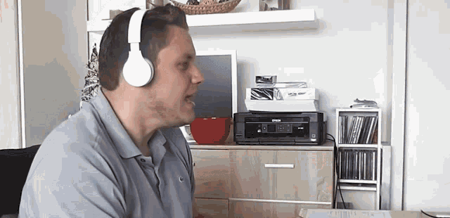 a man wearing headphones is singing in front of a printer