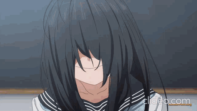 a close up of a girl covering her face with her hair and the words clideo.com below her