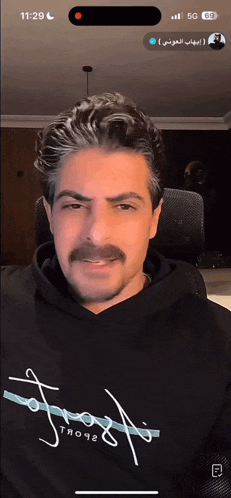 a man with a mustache is wearing a black hoodie that says frost on it