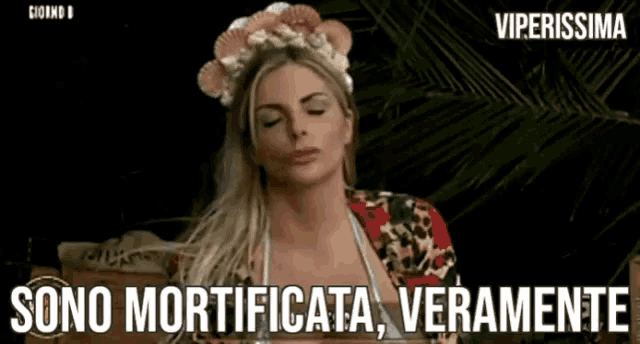 a woman in a bikini is wearing a crown of seashells and says sono mortificata veramente