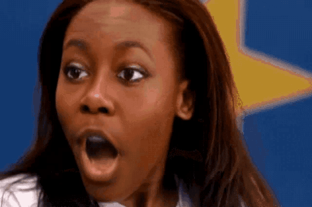 a close up of a woman 's face with her mouth wide open