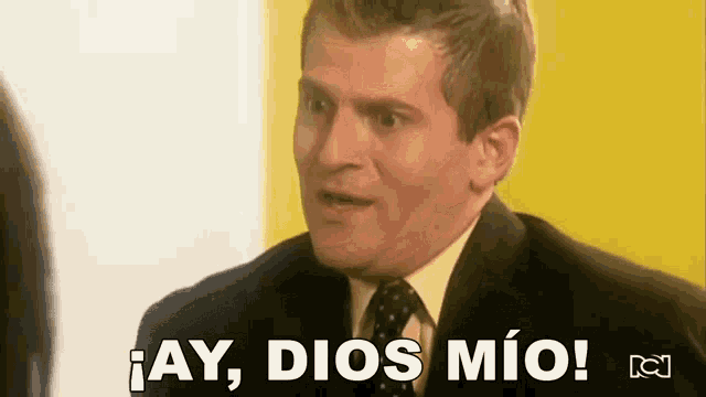 a man in a suit and tie is saying ay dios mio !