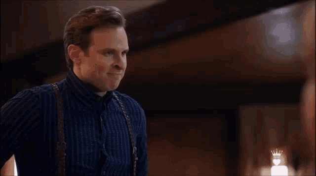 a man in a blue shirt with suspenders says " okay "