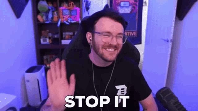 a man wearing glasses and headphones is sitting in front of a microphone and says stop it