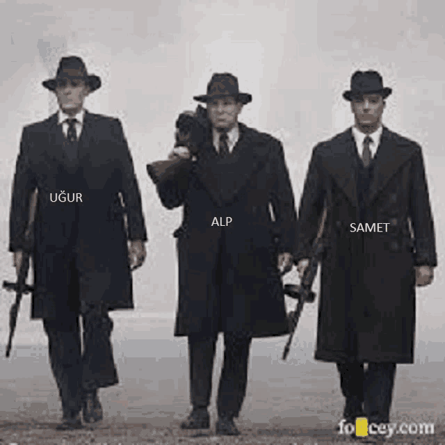 three men in suits and hats are walking down a dirt road with guns .