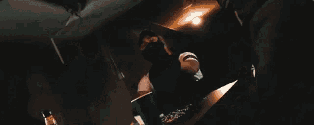 a group of people are dancing in a room with their arms in the air .