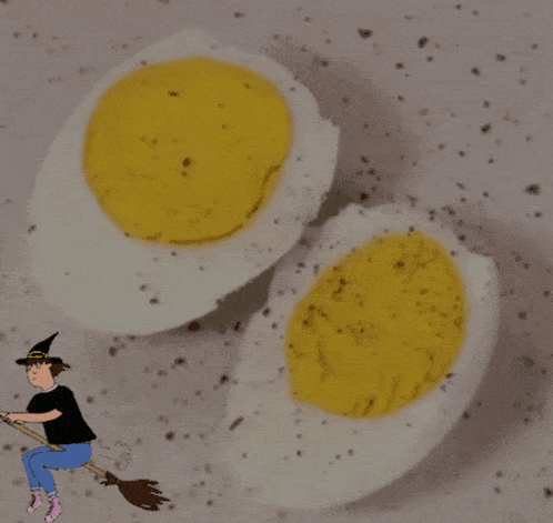 two hard boiled eggs on a plate with a witch on a broom