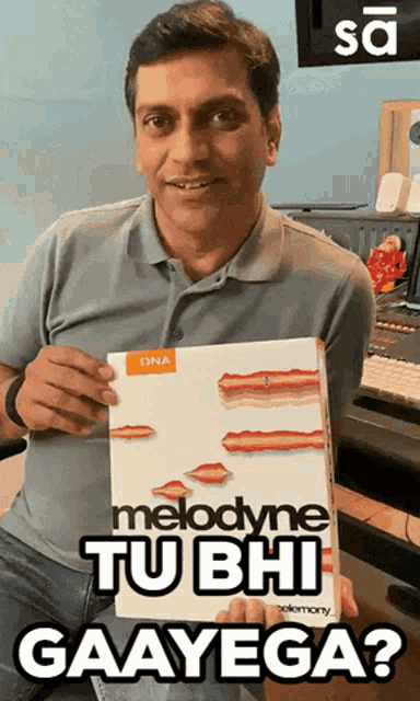 a man holding a box that says melodyne tu bhi gaayega