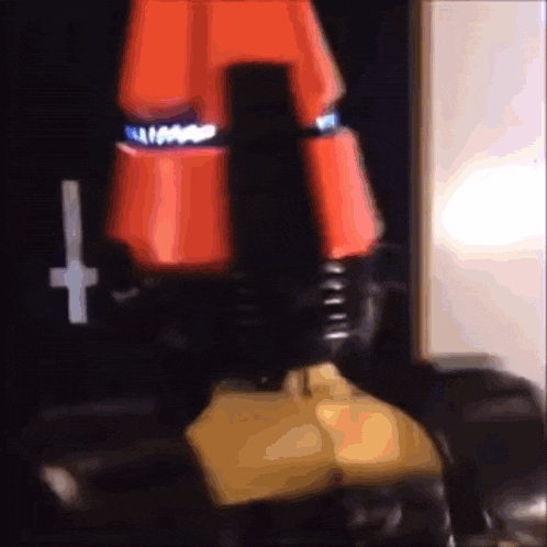 a person wearing red pants and black boots with a cross on their knee