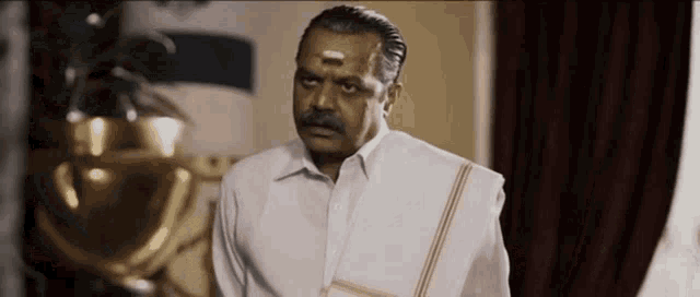 a man with a mustache is wearing a white shirt .