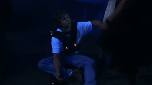 a man sitting on the floor with a gun in his hand