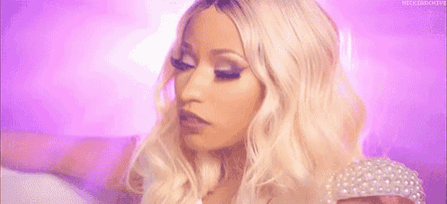 a close up of a woman 's face with blonde hair and pearls .