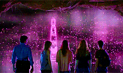 a group of people standing in front of a purple light