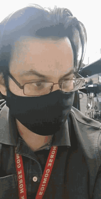 a man wearing a mask and glasses has a lanyard that says horse comics