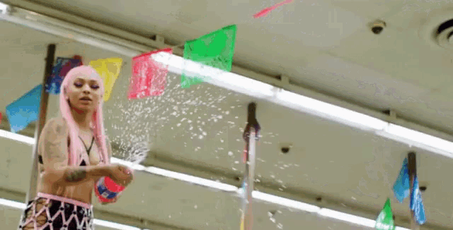 a woman in a pink wig is holding a spray bottle in a store .