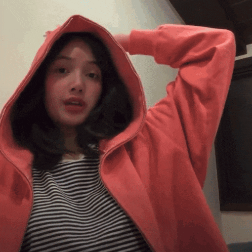 a girl wearing a red hoodie and a striped shirt