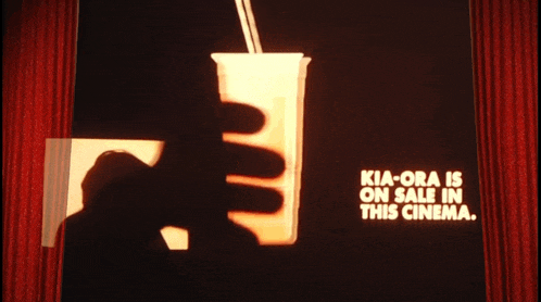 a shadow of a person holding a cup with a straw and the words kia-ora is on sale in this cinema