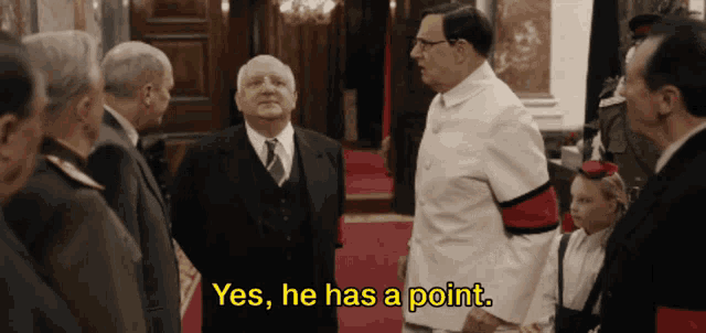 a group of men are standing in a room with the words yes he has a point