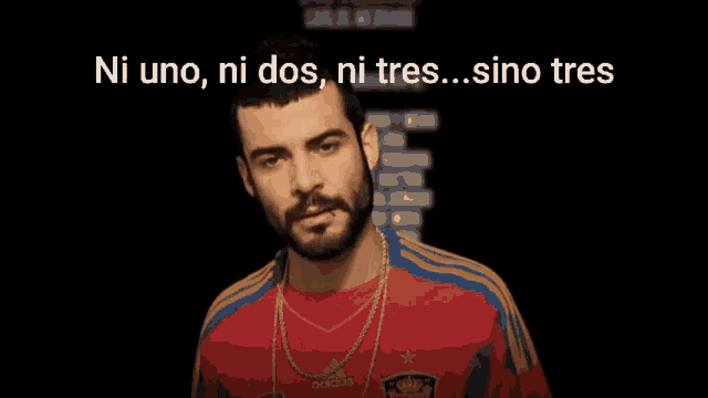 a man with a beard wearing a red adidas shirt giving the middle finger