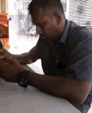 a man wearing a watch is looking at his phone